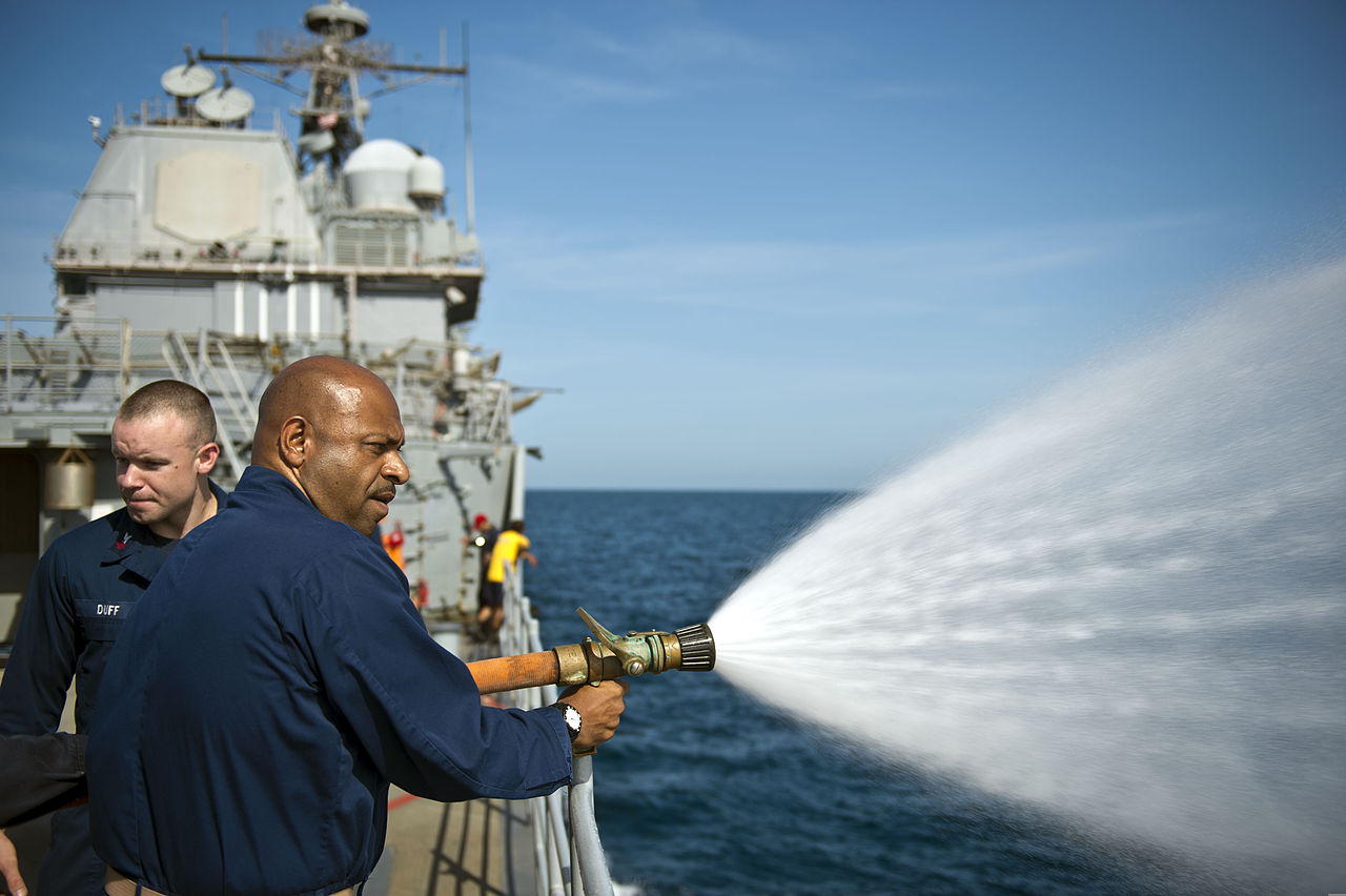 An image of a person spraying water from a large hose.