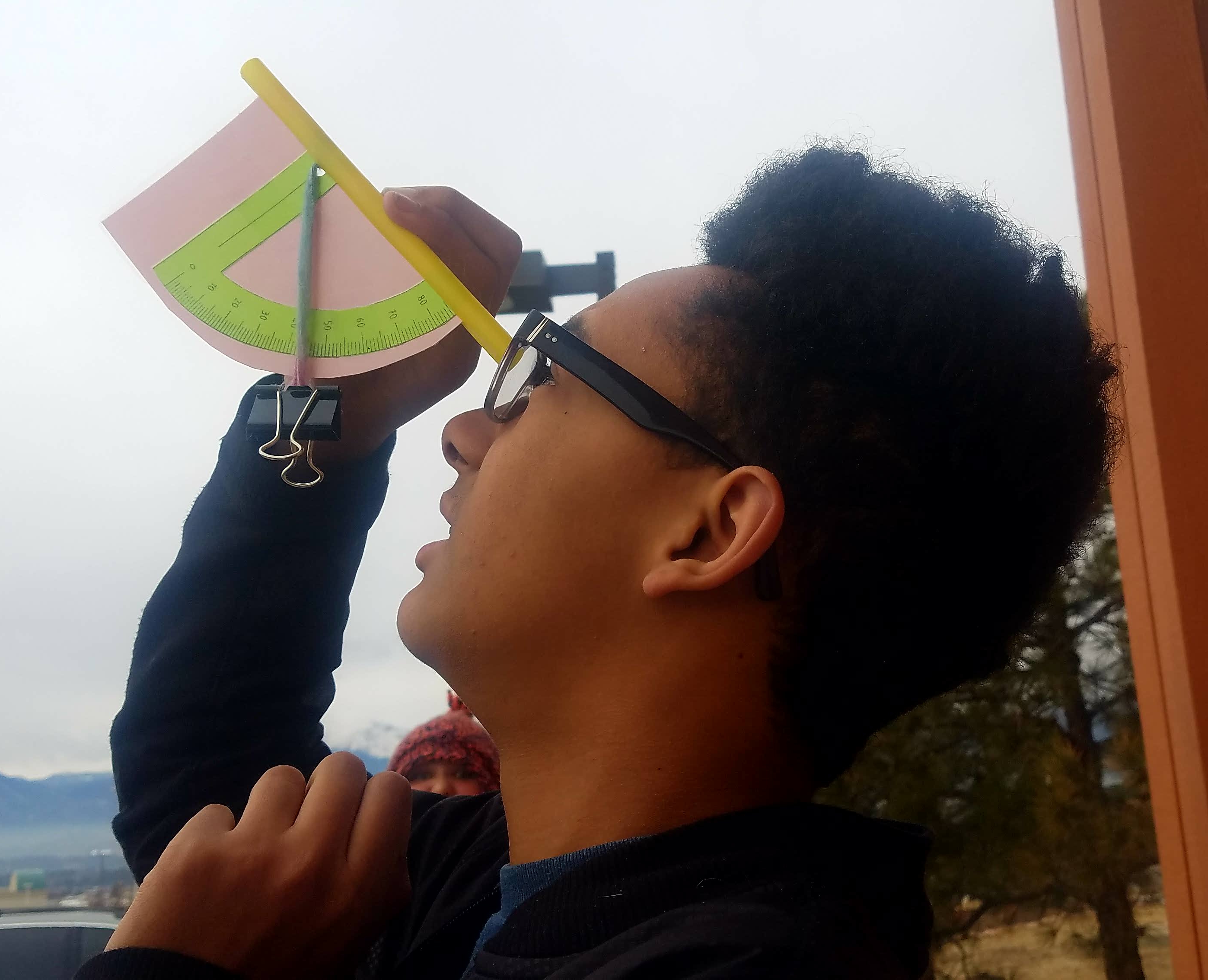 <p>Student with handmade clinometer.</p>
