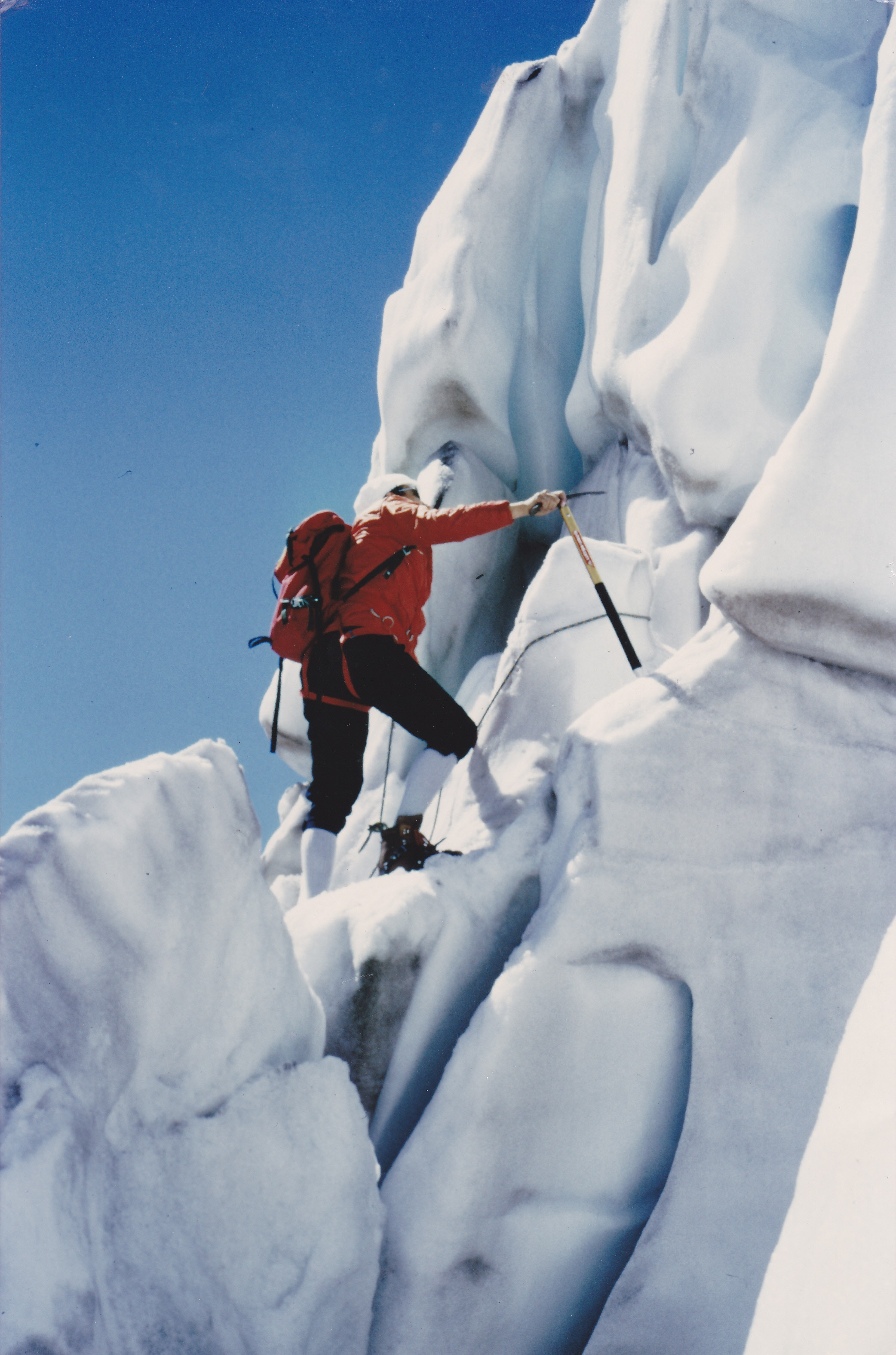 <p>An image of a mountaineer climbing up a wall of ice. </p>
