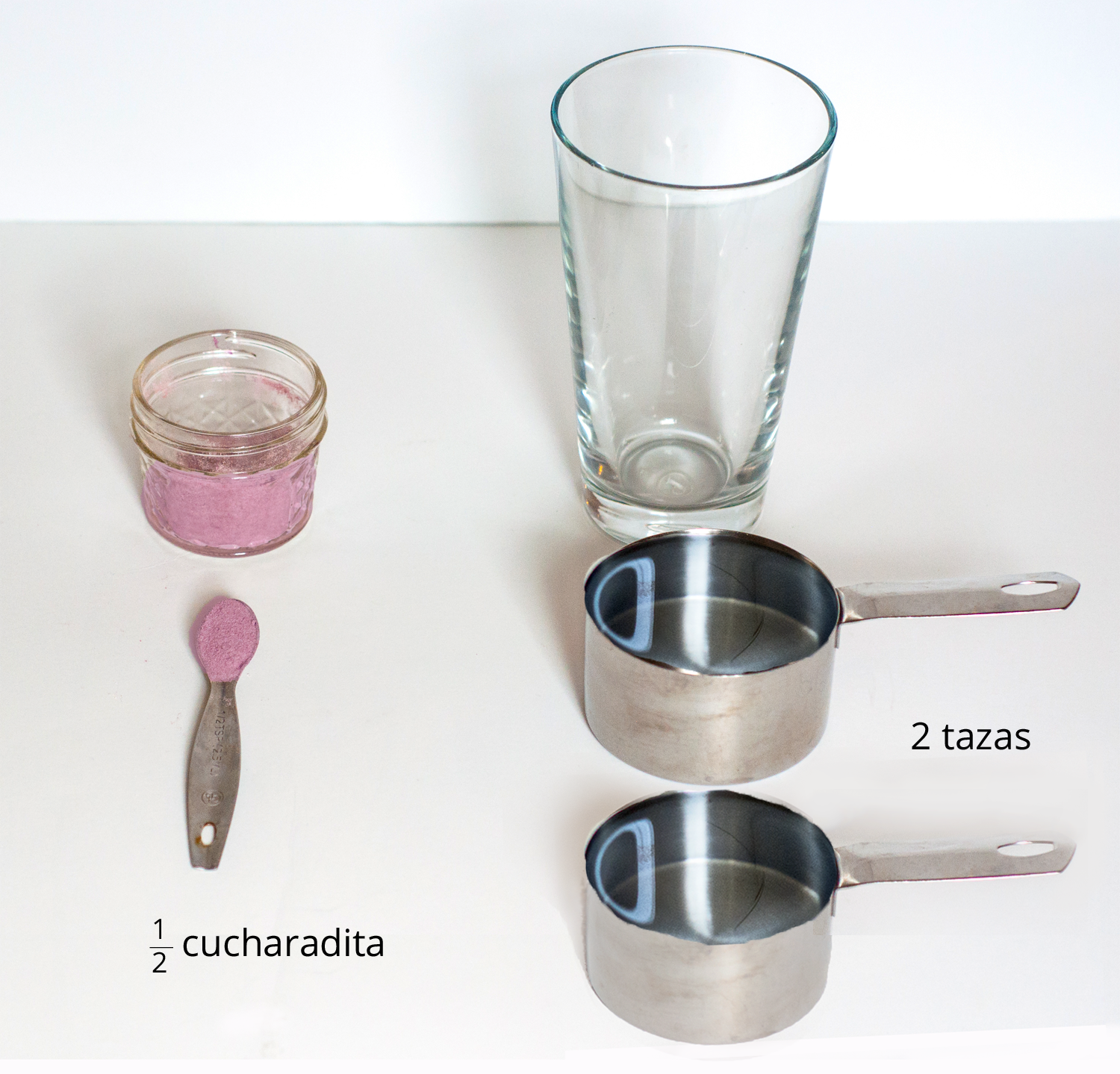 A picture of a glass, drink mixture in a container, one half of a teaspoon of drink mix, and 2 measuring cups.