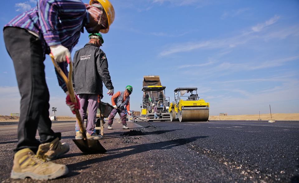 <p>Construction workers laying asphalt.</p>
