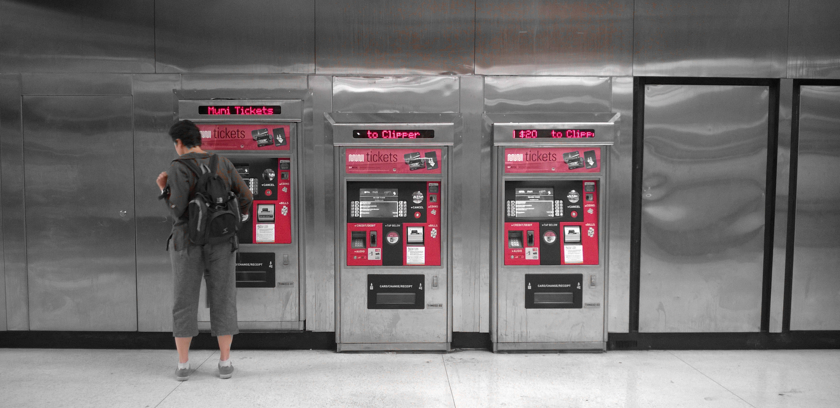 <p>Person at a fare card machine</p>
