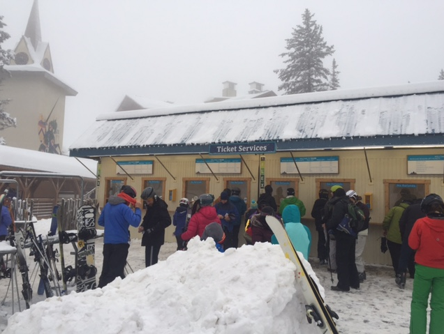 <p>A picture of people waiting to buy tickets to ski or snowboard.</p>
