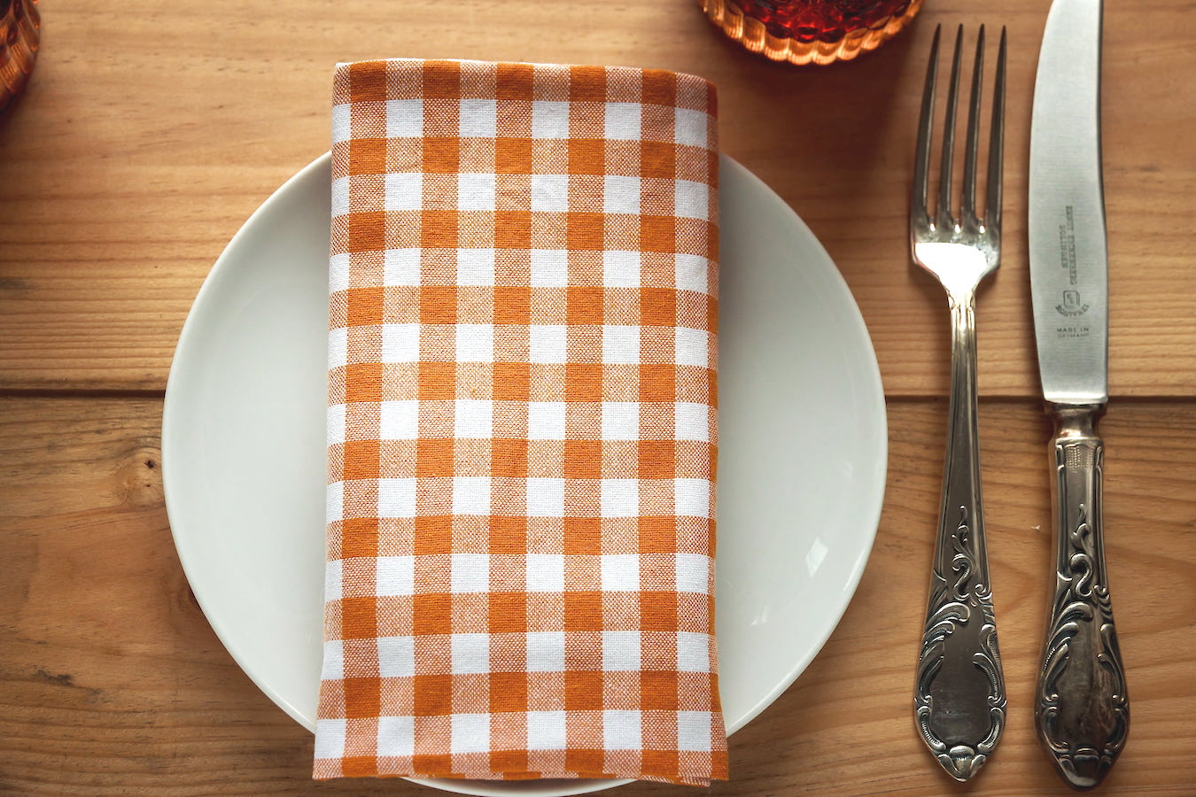 photograph of a table setting with a plate, napkin, fork, and knife.