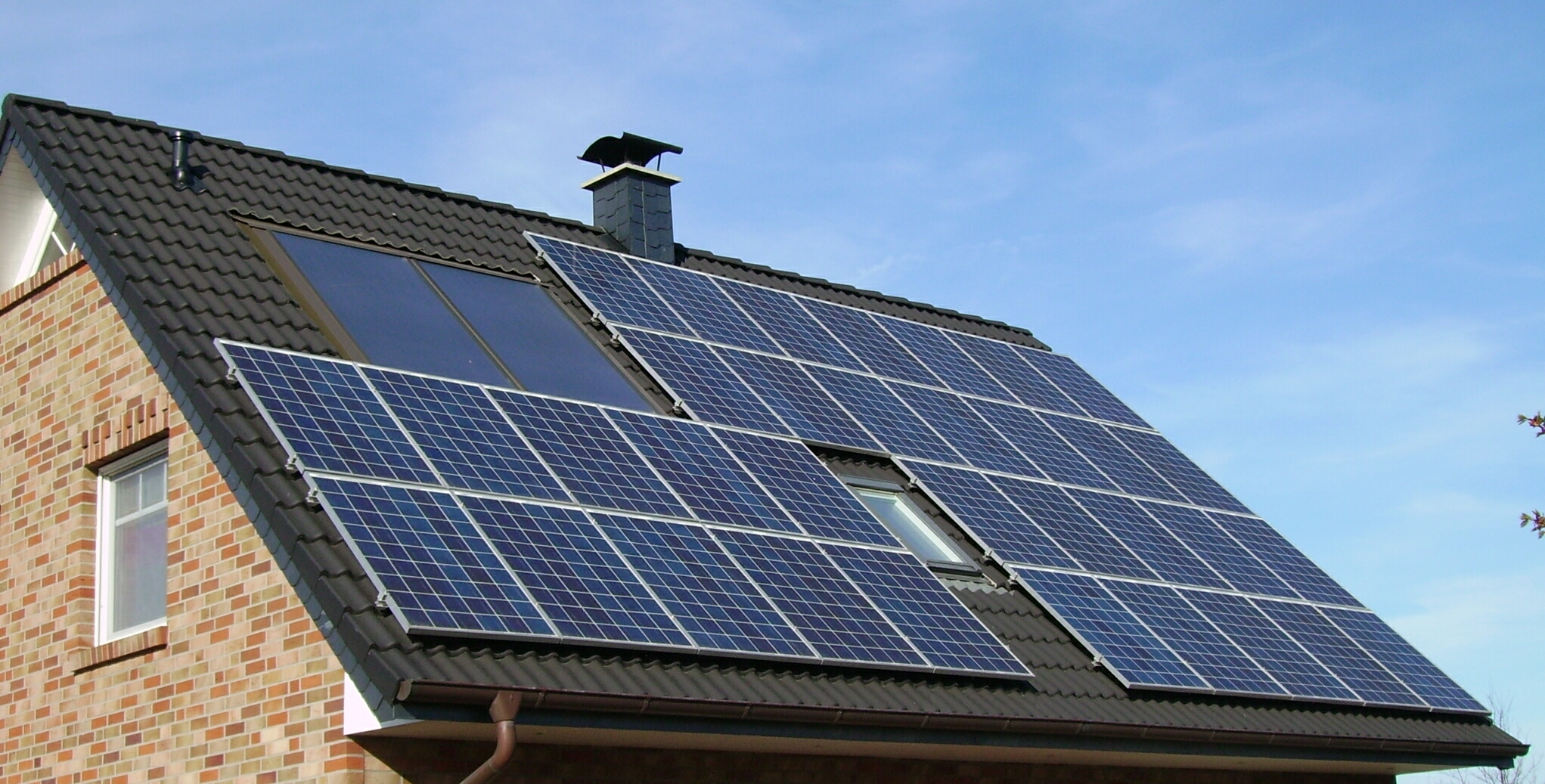 <p>An image of the side of the roof of a house. The roof has solar panels on it. </p>

