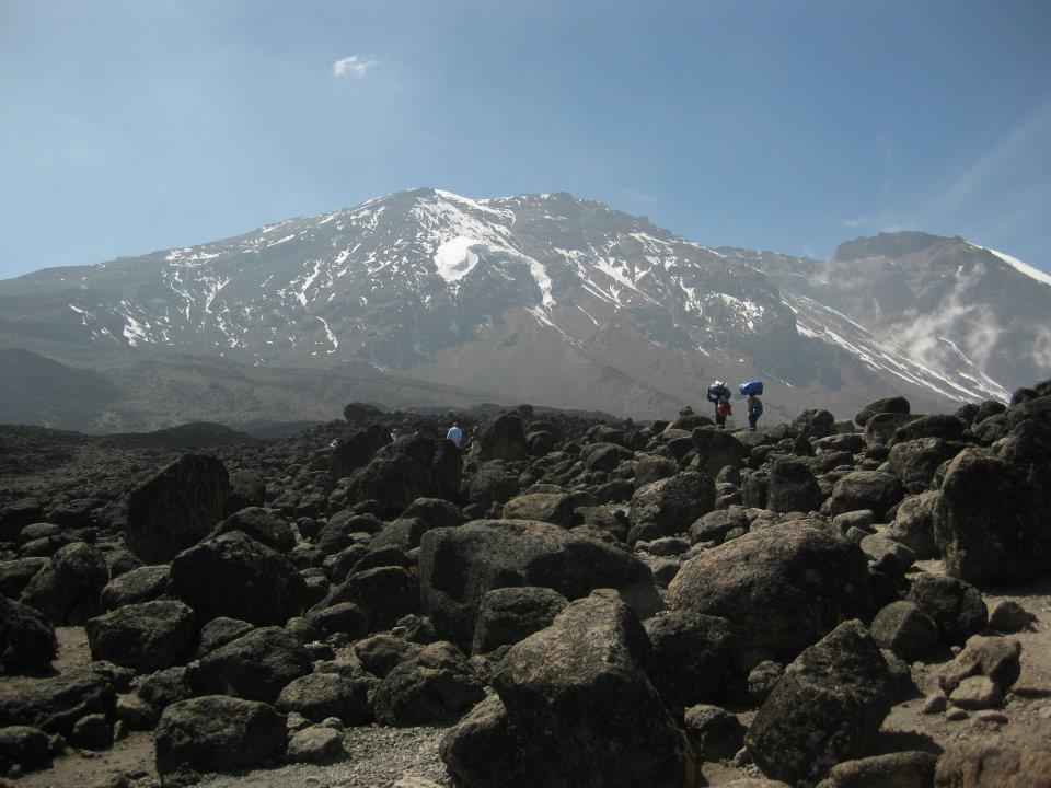 A photo of people standing in front of a large mountain.