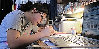 <p>photo of student doing homework</p>

