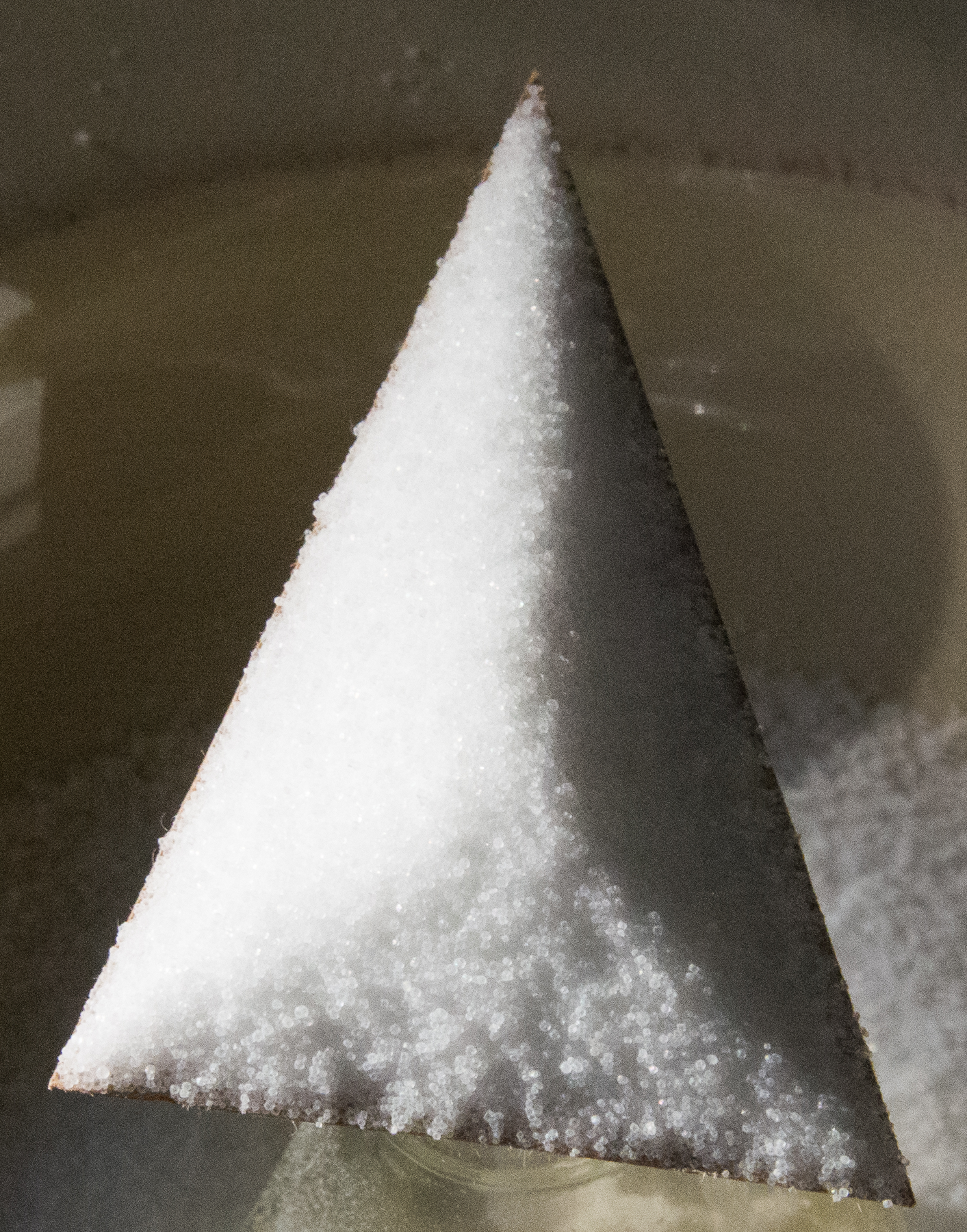 <p>Cardboard triangle on top of glass bottle, with salt on top of entire triangle.</p>
