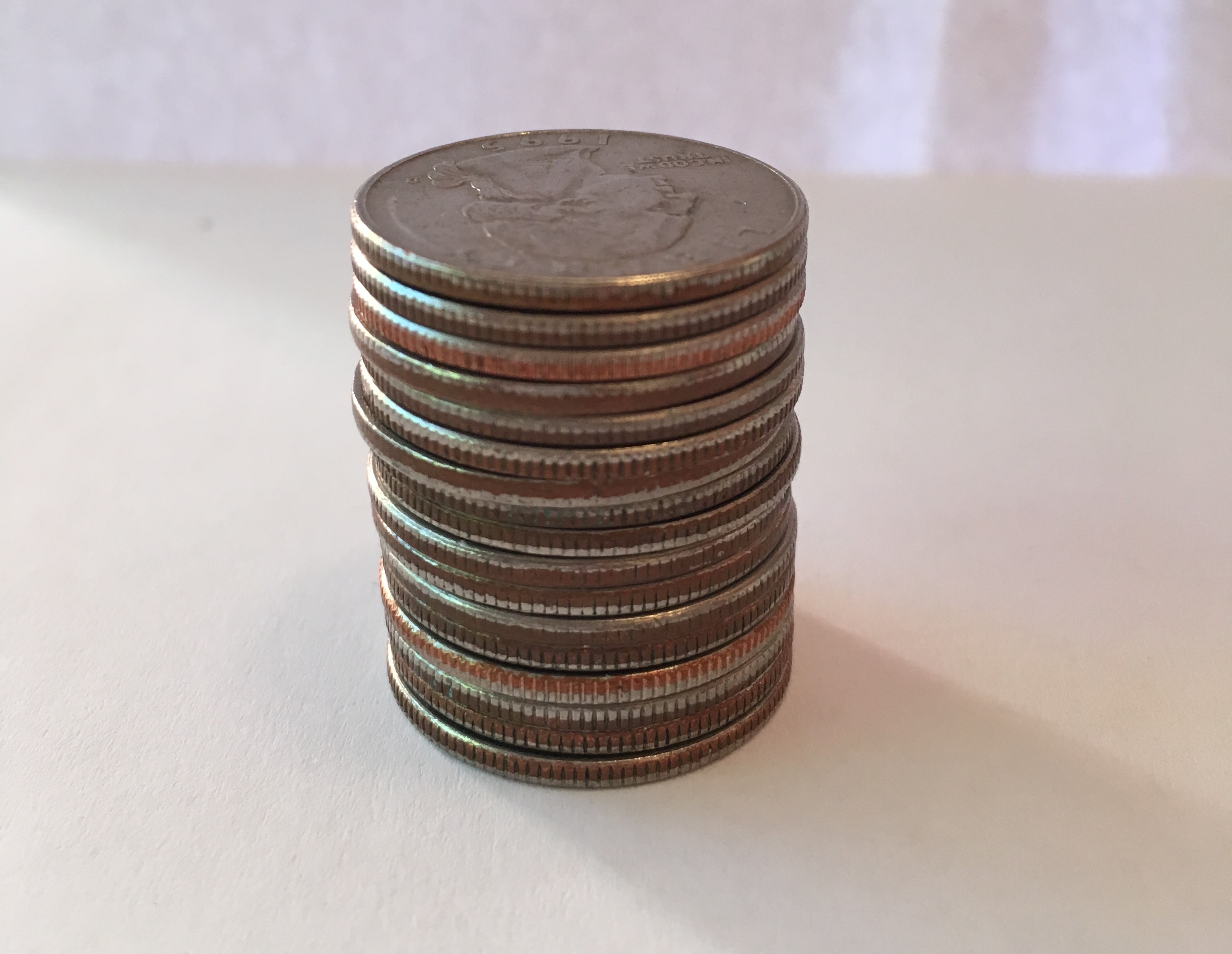 <p>A photo of a stack of coins, quarters.</p>
