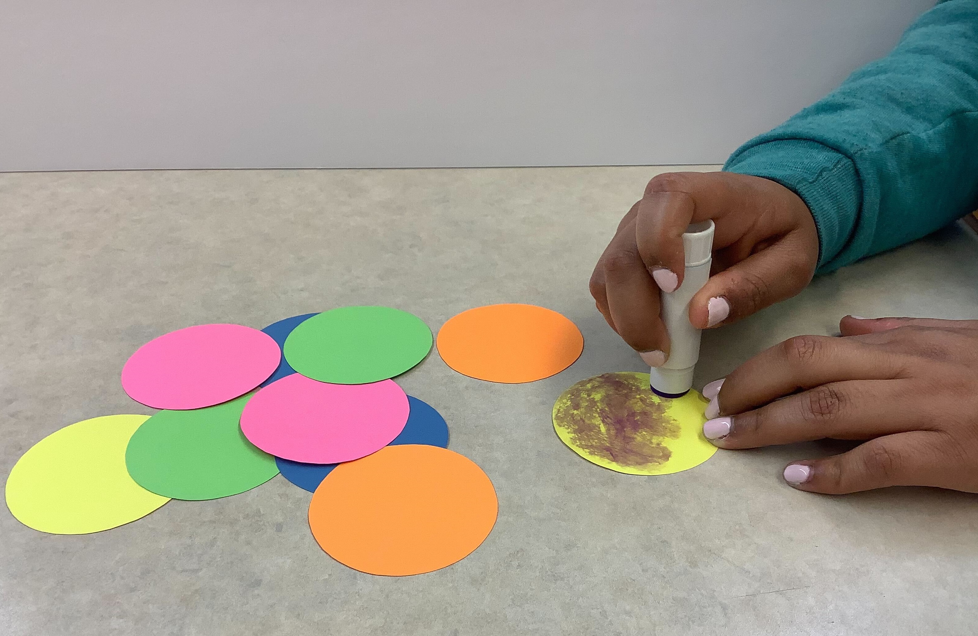 Image of a person using a glue stick.