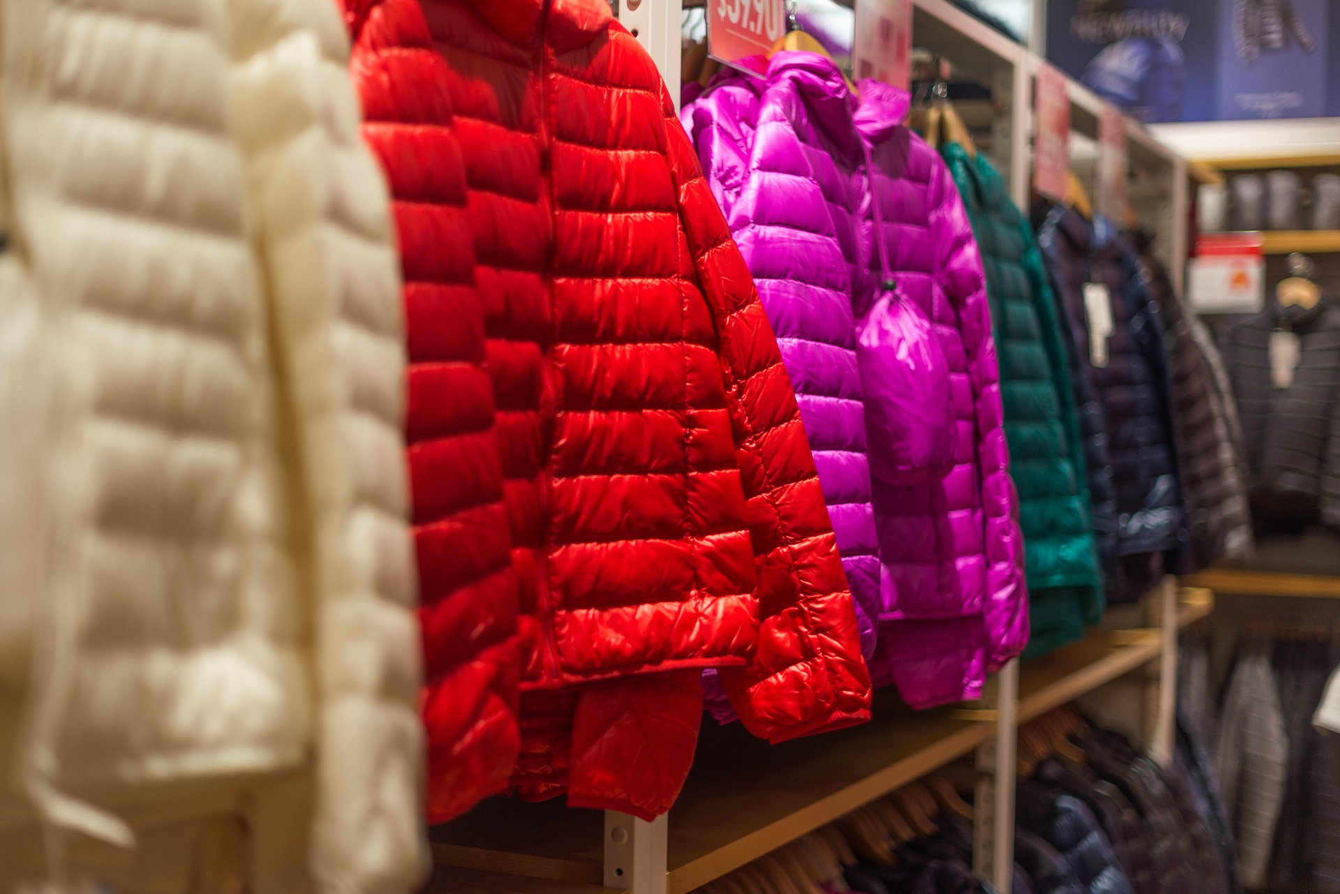 <p>a photo of down jackets hanging in a store</p>
