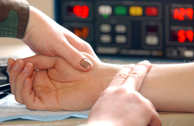 <p>woman taking man's radial pulse</p>
