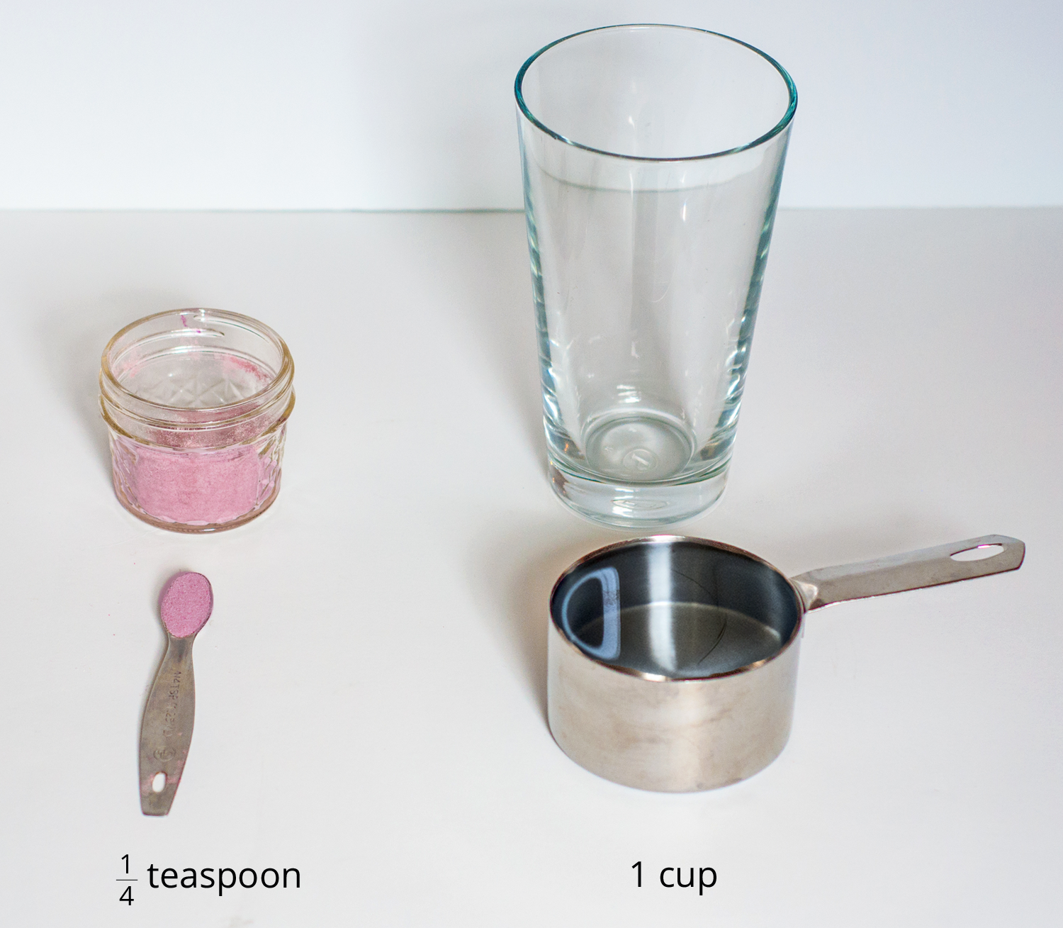 <p>A picture of a glass, drink mixture in a container, a quarter teaspoon of drink mix, and a measuring cup.</p>
