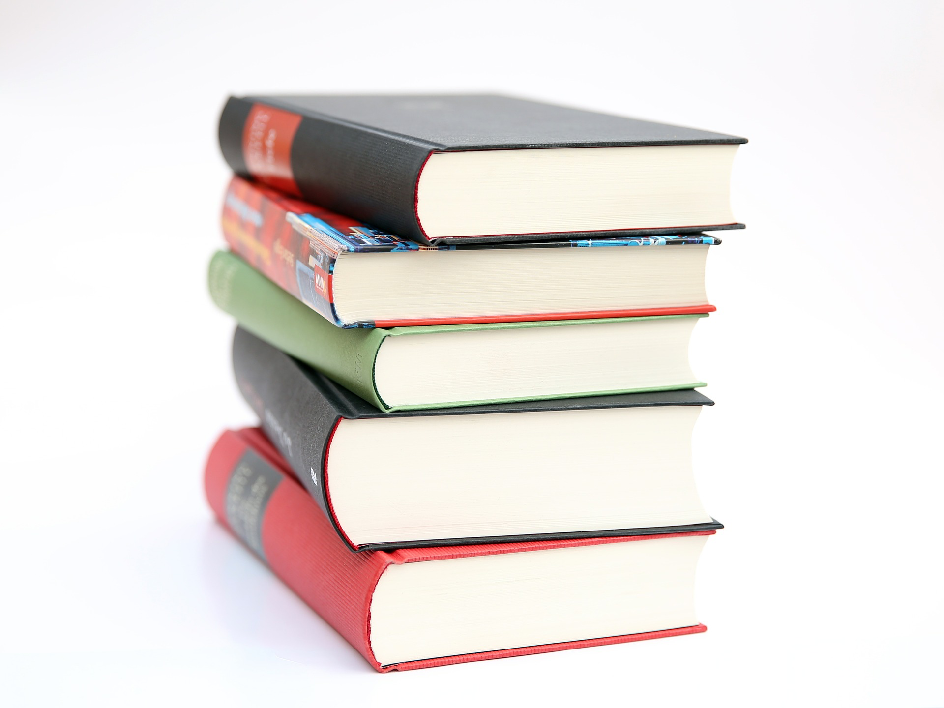 An image of 5 different-sized books, stacked on top of one another.